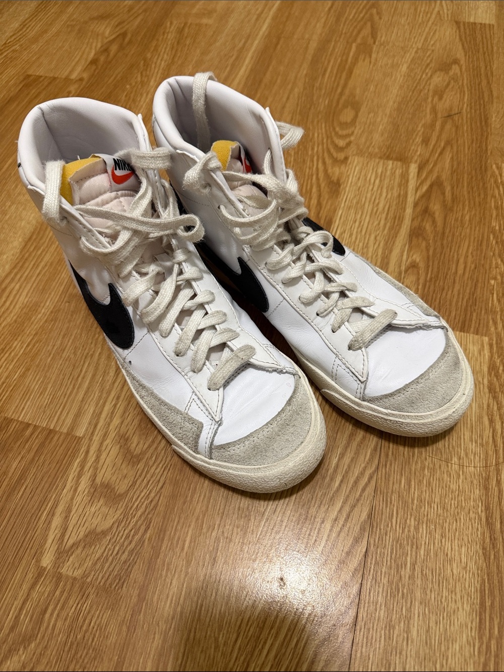 Nike White High-Top Sneakers with Black Swoosh and Yellow Tongue Accent